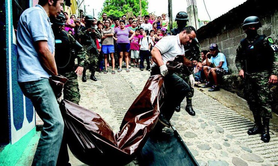 Et drapsofer bæres bort av politiet, mens naboene ser på, tilsynelatende uberørt. Hvert år blir 7000 mennesker drept i Honduras. Et drapsofer bæres bort av politiet, mens naboene ser på, tilsynelatende uberørt. Hvert år blir 7000 mennesker drept i Honduras.