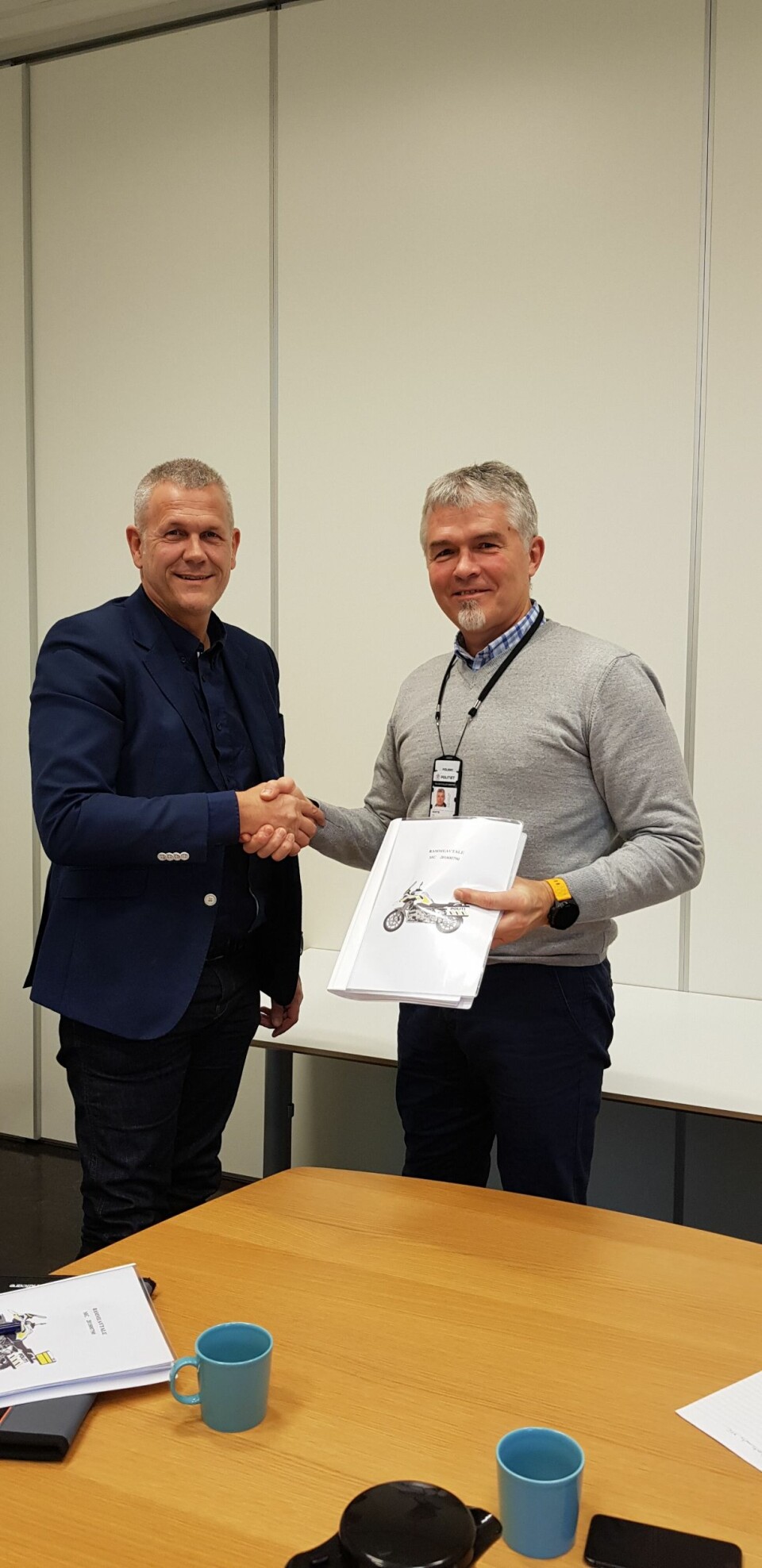 Arild Saastad fra Handicare og Luc Martin fra Politiets Fellestjenester har signert kontrakten for ny motorsykkel.