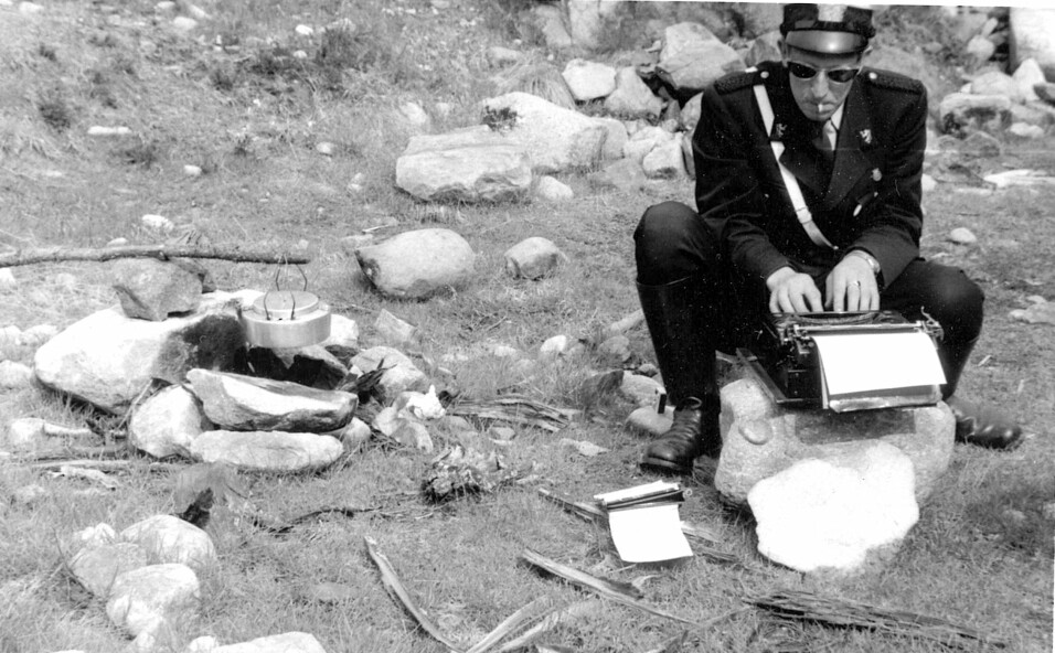POLITIARBEID PÅ STEDET: Politikonstabel Lars Grøndal sitter på en stein og skriver rapport på en skrivemaskin ved veikanten i Østerdalen. Året er 1958.