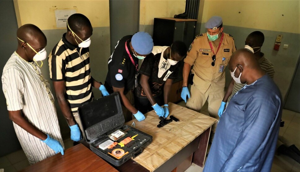 OPPLÆRING: Her viser politimannen Rodrigue Nzyoibuka og politiinspektør Gustav Landro (nummer tre og fem fra venstre) hvordan krimteknikere fra Malis best gjennomfører bevissikring av våpen.