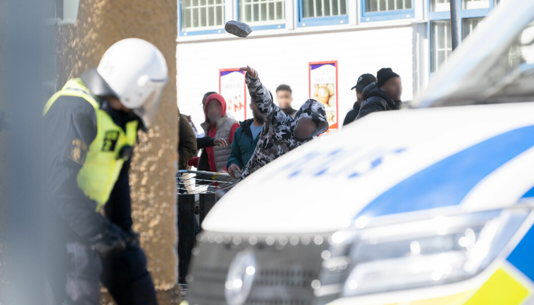 UNDER ANGREP: Politiet ble møtt av flere hundre motdemonstranter, som kastet store brosteiner mot dem, her i Stockholm-forstaden Rinkeby.
