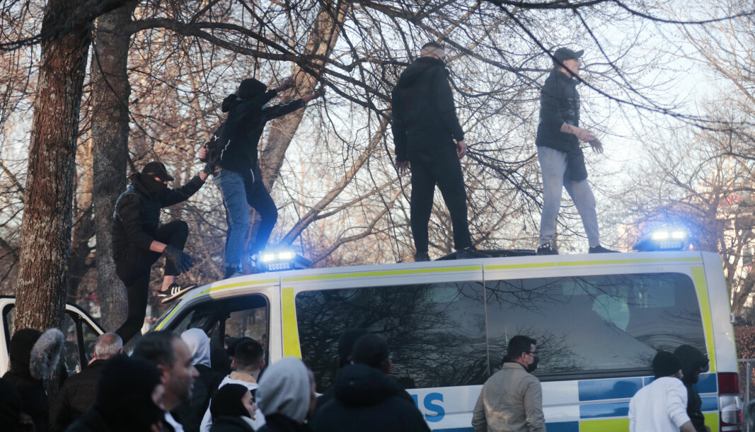 Demonstranter klatrer opp på en politibuss i Sveaparken i Örebro i påsken.