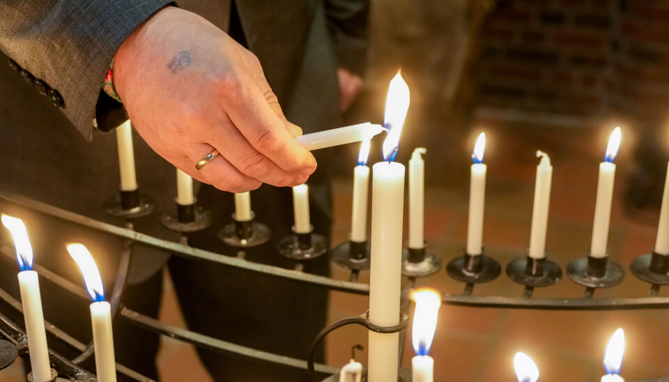 Prost Espen Andreas Hasle tenner lys i Ski nye kirke etter et dobbeltdrap i Ski i desember 2024.