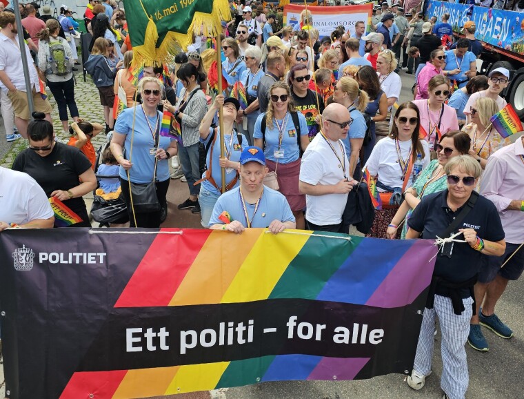 OPPFORDRING:– Nå som vi nærmer oss Pride, er mitt hovedbudskap at ledere og ansatte bør støtte opp om Pride, sier Kari Anne Kristiansen, som
står til høyre for flaggbæreren, i blå t-skjorte og solbriller.