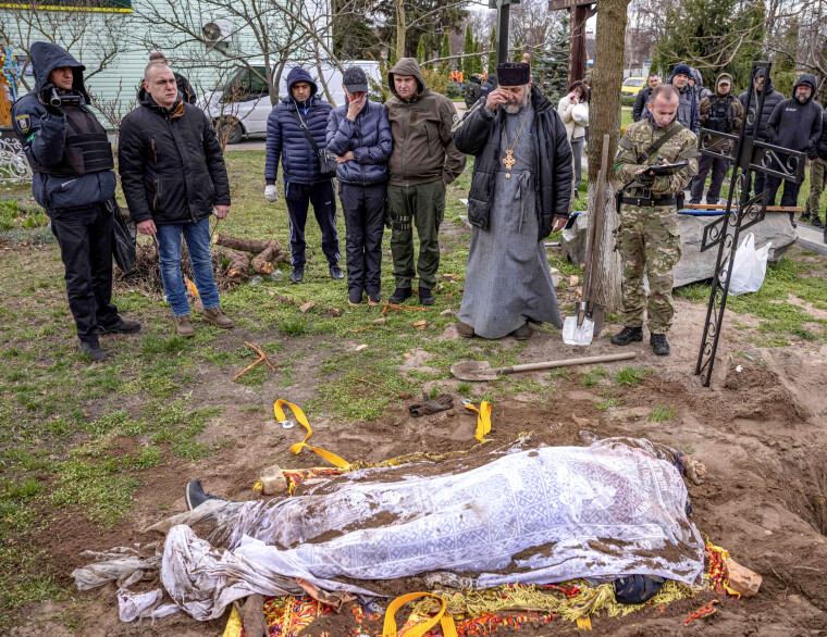 BRUTALT: Kapten Bogdan Zlotenko (uniformert, til høyre) under
etterforskningen av drapet på ordfører
Yuriy Prylvpko i Hostomel, like utenfor Kyiv.
Ordføreren ble drept av russiske soldater
7. mars 2022 mens han delte ut mat og
medisiner til innbyggerne.