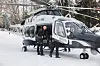 Politihelikopter på bakken i snø mens mannskap forbereder avgang.