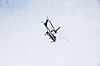 Helikopter med redningsutstyr flyr over en lys og skyet himmel