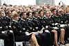 Rekke på rekke med politistudenter i uniform sitter på stoler under en seremoni.