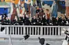 En gruppe mennesker i uniform står samlet foran et veggmaleri inne i Oslo rådhus.