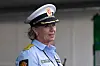 En kvinnelig politibetjent i uniform står utendørs og ser mot siden.
