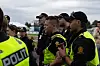 En gruppe politifolk står samlet utendørs med gule refleksvester og svarte uniformer.