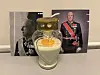 Et dekorert minneglass står foran et fotografi av Kong Harald i uniform.