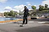 Politibetjent styrer en liten drone på en asfaltert plass ved vannet i Oslo.